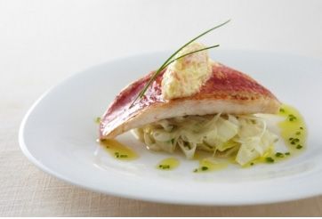 Un plat de rouget croustillant au fenouil et vinaigrette au crabe